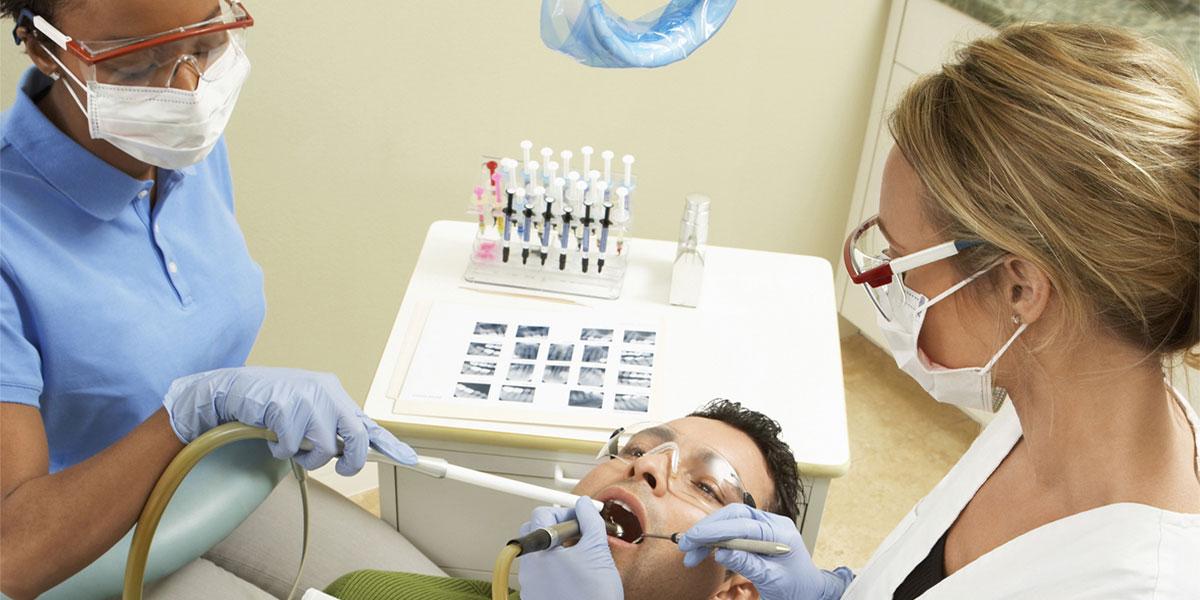 Dentist and dental assistant with patient 